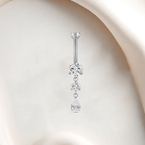 Macro detail of F136 titanium belly ring with dangling white zircon waterdrop crystals