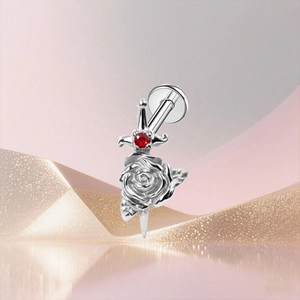 Detail of G23 titanium stud featuring a sword piercing a rose with a red zircon stone