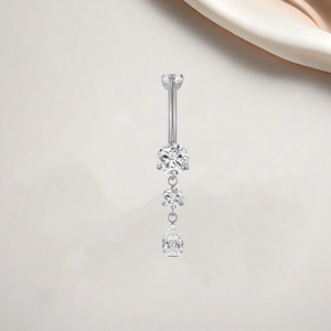 Detail of silver titanium belly ring featuring tiered round and pear-shaped zircons