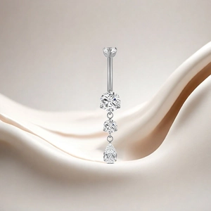 Macro detail of F136 titanium belly ring with dangling pear-shaped zircon stones