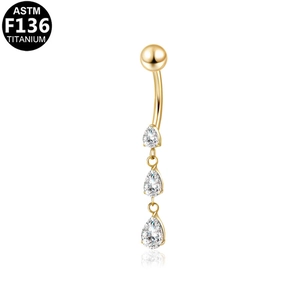 Close-up of golden ASTM F136 titanium belly ring with three teardrop zircon pendants