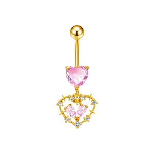 Dettaglio ravvicinato del piercing all'ombelico dorato con pendente a cuore rosa