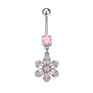 Dettaglio di un piercing all'ombelico argento con ciondolo a fiore rosa e zircone bianco
