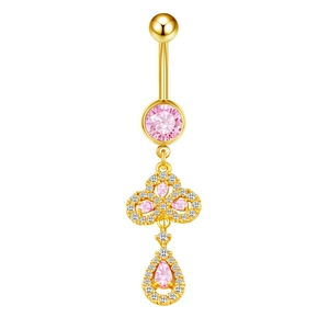 Detailed macro view of pink zircon pendant and gold curved barbell belly button ring