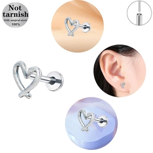 Detail of 316L surgical steel heart-shaped piercing with twisted cross design