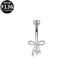 Vista dettagliata del piercing all'ombelico in titanio ASTM F136 con fiocco e cuore