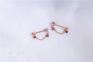 Detail of rose gold nipple rings with purple star zircon and hanging beaded chains