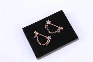 Detail view of rose gold nipple rings with purple star zircon and delicate chain fringe