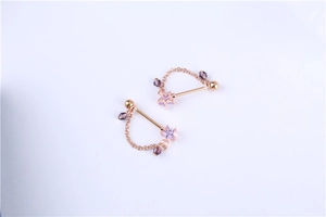 Detail of rose gold nipple rings with purple star zircon and hanging decorative chains