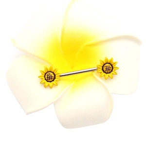 Detailed view of sunflower nipple ring piercing jewelry placed on a white frangipani flower