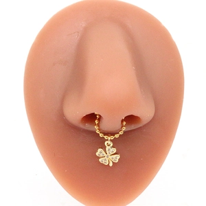 Gold non-pierced stainless steel nose ring with sparkling clover pendant on model