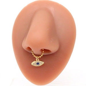 Detailed close-up of golden evil eye septum ring with blue gemstone on silicone model