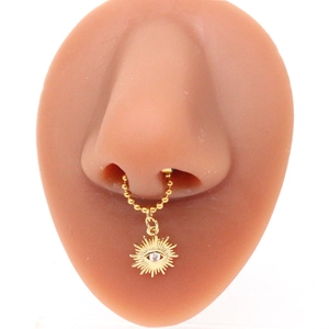 Detailed view of a gold beaded nose ring with a sun pendant and clear cubic zirconia stone