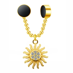 Close-up of golden magnetic nose ring with a sparkling rhinestone sun pendant