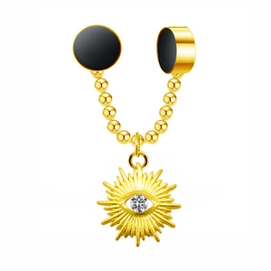 Macro detail of gold-toned sun and eye charm with a clear zircon on a black bead chain