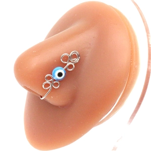 Detail of silver wire wrapped non-piercing nose ring with blue evil eye bead charm