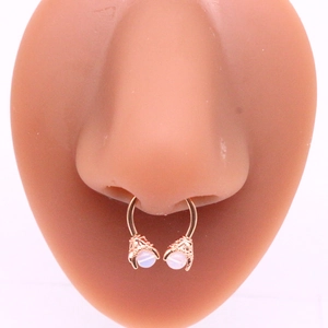 Dettaglio del septum in oro rosa con artigli di drago e pietre di opale su modello di naso