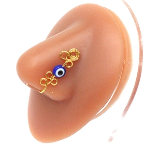 Detail of handmade gold wire evil eye nose cuff on a model without piercing needed