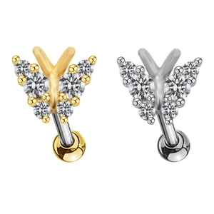 Détail de piercings de nombril papillon avec cristaux brillants en finitions or et argent