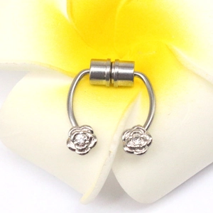 Macro shot of silver magnetic U-shaped nose ring with rose flower and zircon detail