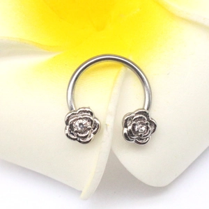 Macro shot of stainless steel horseshoe nose ring with crystal rose-shaped ends