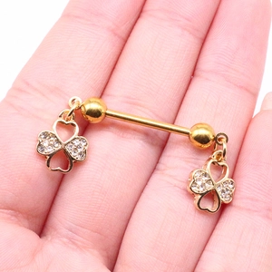 Detailansicht eines goldenen Kleeblatt-Brustpiercings mit funkelnden weißen Zirkonia-Steinen