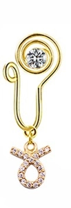 Detail of a gold Taurus zodiac nose cuff with wire wrap design and zircon pendant