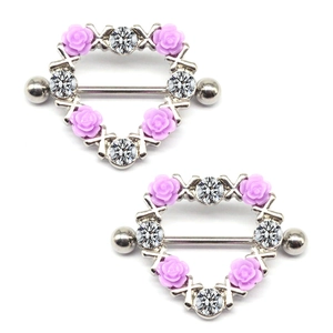 Detailed view of silver heart-shaped nipple rings with purple resin roses and zircons