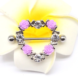 Macro detail of heart-shaped nipple ring with lavender roses and sparkling cubic zirconia