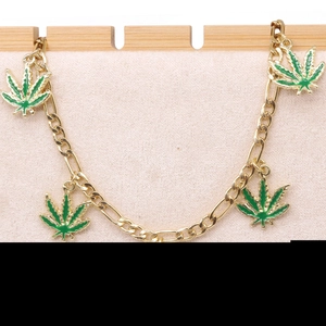 Goldkette mit grünen Blattanhängern, präsentiert auf einem professionellen Displayständer