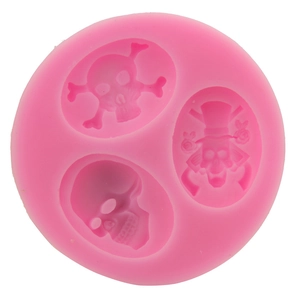 Macro detail of pink silicone cake mold featuring three distinct skull designs for baking