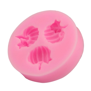 Detailed macro view of pink silicone mold featuring three distinct leaf patterns for fondant