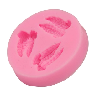 Macro detail of pink silicone mold with three realistic corn-shaped cavities for baking