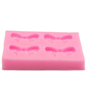 Detail of pink silicone mold with four bow shapes for DIY fondant and cake decorating