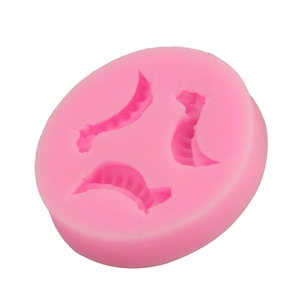 Macro detail of pink silicone mold featuring three dumpling shaped cavities for DIY baking
