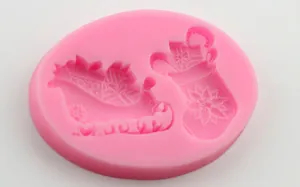 Pink silicone mold featuring Christmas sleigh and stocking designs for DIY baking and crafts