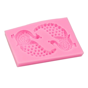 Macro detail of pink silicone mold featuring two symmetrical peacock paisley patterns
