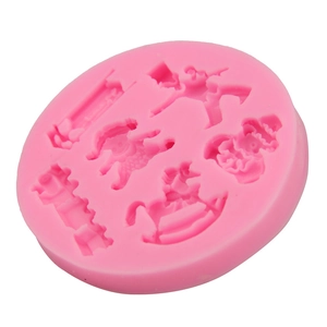 Detail view of pink silicone mold with carousel horse and doll relief patterns