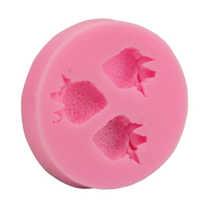 Détail d'un moule en silicone rose avec trois cavités en forme de fraise pour le cake design