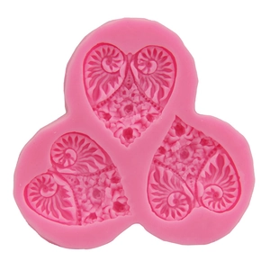 Pink silicone mold with three heart shapes featuring intricate spiral texture and floral relief