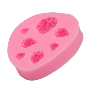 Dettaglio di uno stampo in silicone rosa con sette diverse cavità a forma di frutti