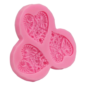 Detailed macro view of pink silicone mold featuring three intricate heart relief patterns
