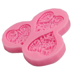 Detailed close-up of pink heart-shaped silicone mold with floral and leaf patterns