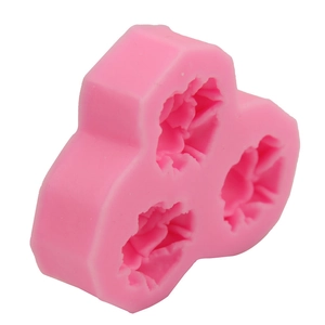 Dettaglio ravvicinato dello stampo in silicone rosa con tre cavità di rose per la cottura