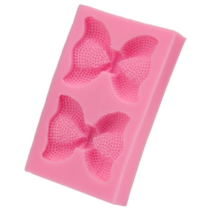 Vue détaillée du moule en silicone rose avec nœuds papillon et texture de maille fine