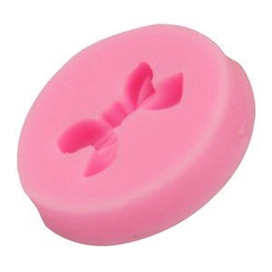Macro shot of pink silicone mold featuring a detailed 3D bow cavity for DIY baking and crafts