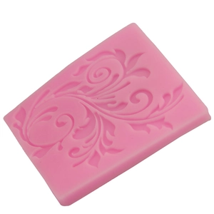 Close-up of pink silicone cake mold featuring intricate floral leaf vine relief patterns