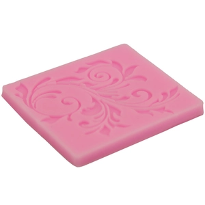 Macro detail of a pink silicone mold with intricate floral scroll texture for baking cakes