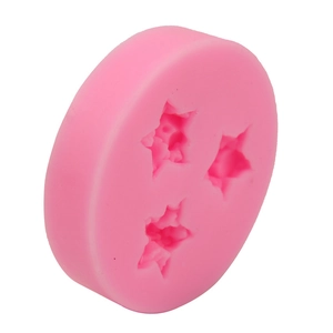 Detailed view of pink silicone mold with three star-shaped cavities for DIY baking