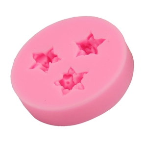 Macro detail of pink silicone mold with three star-shaped cavities for DIY baking